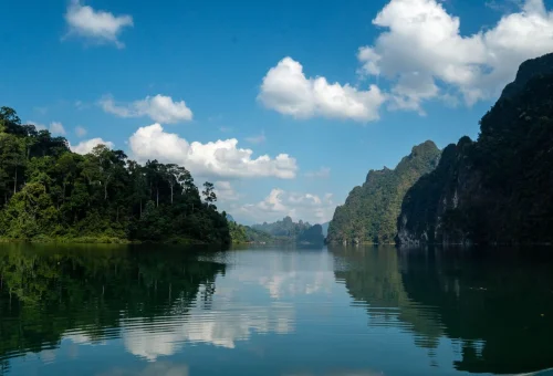 Cheow Lan Lake in Khao Sok National Park surrounded by lush rainforest and limestone cliffs