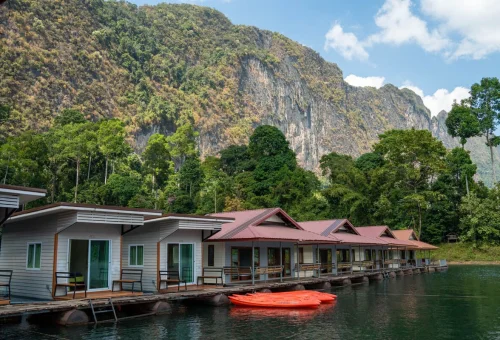 Floating bungalows on Cheow Lan Lake surrounded by rainforest-covered limestone mountains