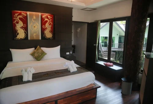 Comfortable bedroom with a double bed inside a treehouse-style resort in Khao Sok