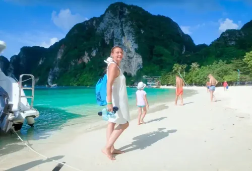 Smiling customer enjoying sunrise boat ride near Phi Phi Islands on Early Bird tour