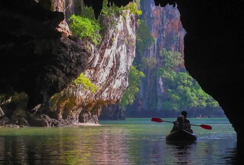 Scenic of Phang Nga Bay with misty limestone islands, calm waters, and golden skies during the early departure James Bond Island Tour.