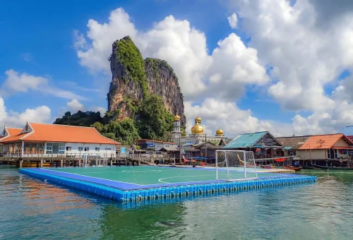 Floating village of Koh Panyee in Phang Nga Bay — traditional stilt houses, mosque, and limestone backdrop, visited during the early departure James Bond Island Tour.