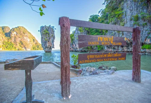 Tourist striking a James Bond pose with a scenic backdrop of Koh Tapu, the iconic "James Bond Island," during the early departure tour from Phuket.