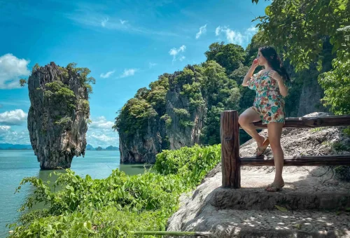 Tourists posing near the iconic James Bond “Golden Gun” display at Koh Tapu, featured in the film The Man with the Golden Gun, during an early departure tour.
