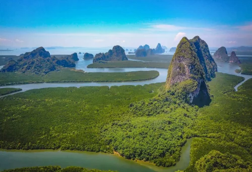 Aerial view of Phang Nga Bay at sunrise — dramatic limestone islands scattered across emerald waters, part of the early departure James Bond Island Tour.