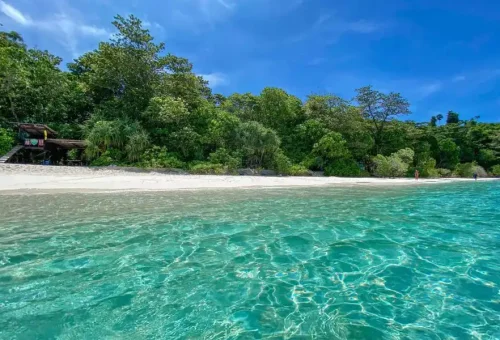 Scenic view of Similan Island No. 8 with white sandy beach, turquoise water, and the iconic granite boulders in the background.