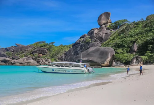 A speedboat arriving at the famous Sailing Rock in the Similan Islands, with turquoise waters and dramatic granite formations.