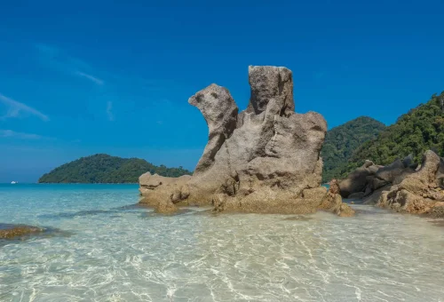 Iconic landmark rock formation at Surin Island surrounded by turquoise waters and lush coastal landscape