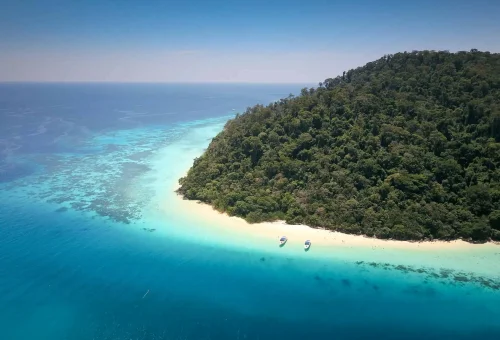 Top aerial view of Koh Rok’s twin islands with white sandy beaches, turquoise waters, coral reefs, and lush greenery
