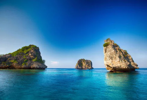Wide-angle view of Koh Haa’s limestone islets surrounded by turquoise waters, coral reefs, and open ocean