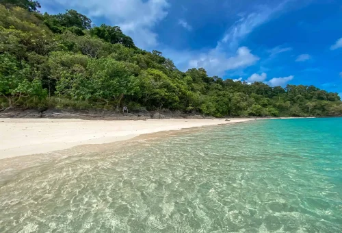 Breathtaking view of Koh Rok with white sand beach, clear turquoise sea, and lush tropical vegetation