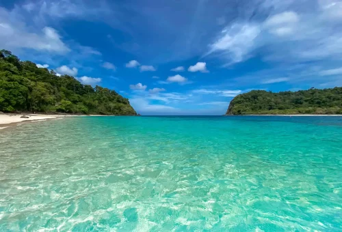 Stunning view of Koh Rok’s twin islands surrounded by clear turquoise water, coral reefs, and white sandy beaches