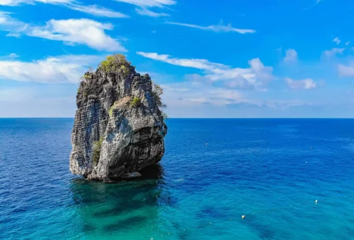 Group of limestone islands at Koh Haa rising from turquoise waters, surrounded by coral reefs and tropical sea