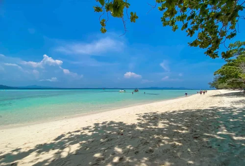 Dreamlike beach scene at Koh Kradan with soft white sand, clear turquoise water, and a peaceful tropical backdrop