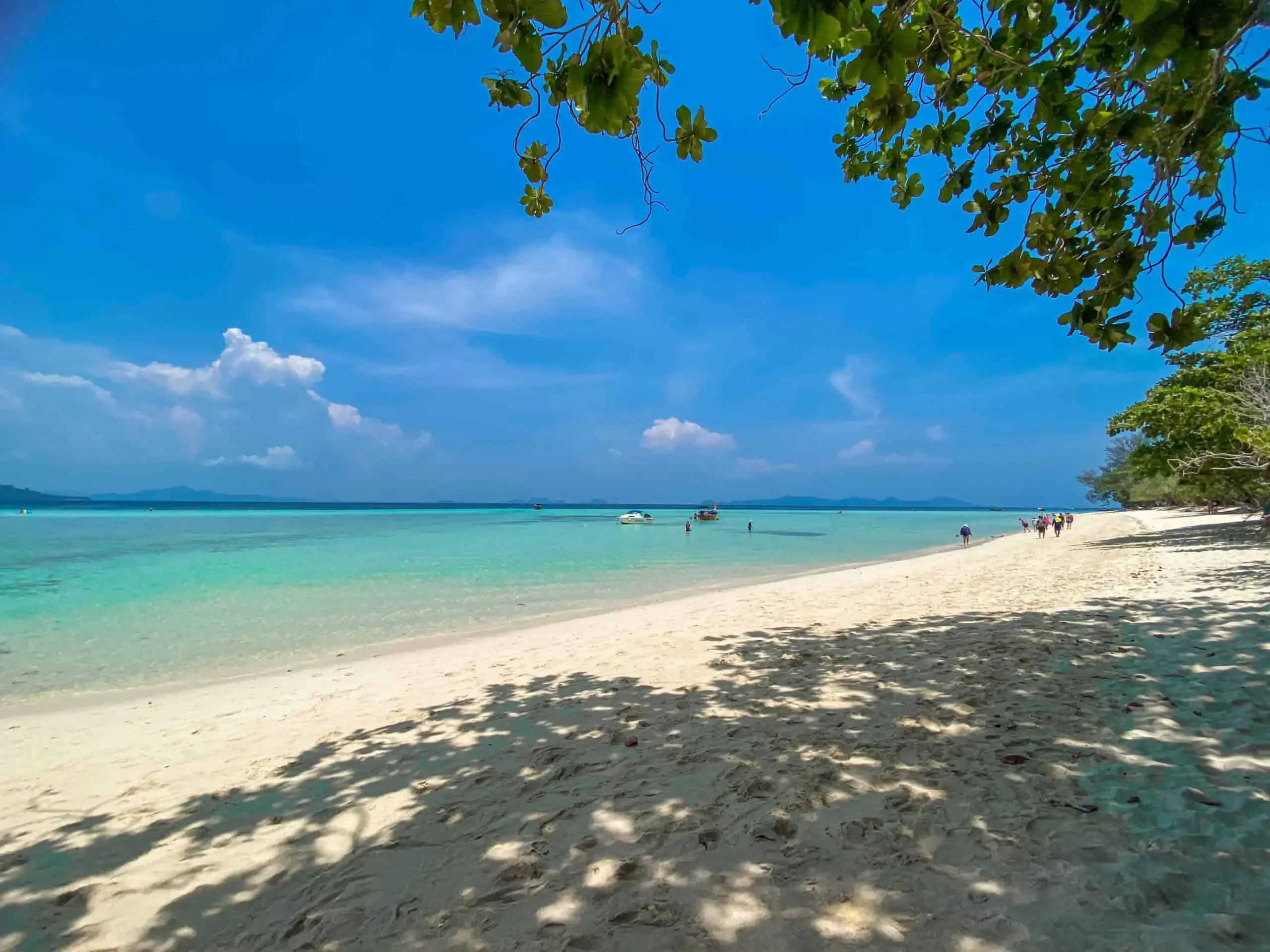 Dreamlike beach scene at Koh Kradan with soft white sand, clear turquoise water, and a peaceful tropical backdrop