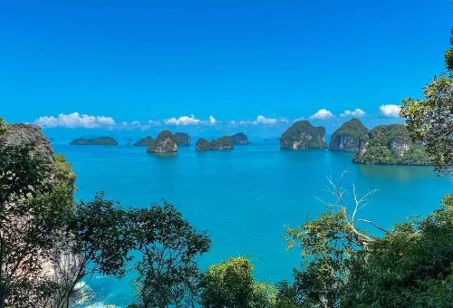 Scenic view of a Krabi island with towering limestone cliffs, turquoise waters, and lush greenery