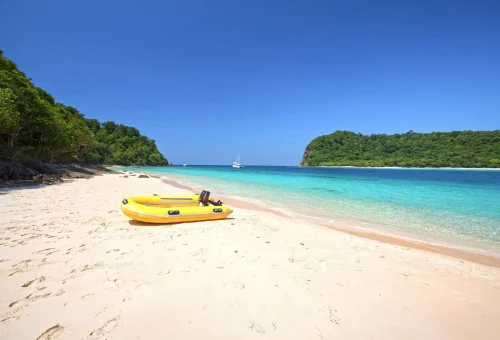 Empty white sandy beach on Koh Rok with clear turquoise water and untouched natural surroundings