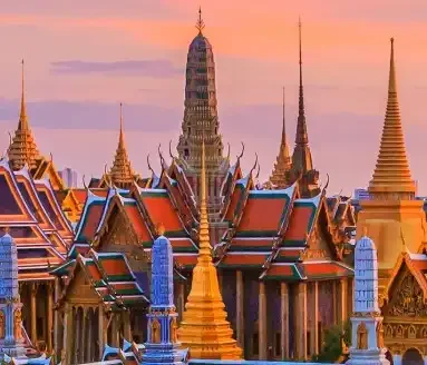 Ornate Bangkok temple with golden spires, intricate details, and traditional Thai architecture under a clear sky