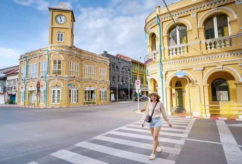 Iconic yellow clock tower in Phuket Old Town, showcasing colonial-style architecture against a clear blue sky