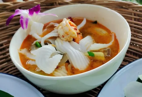 Close-up of a traditional Thai lunch at Old Phuket Farm with freshly prepared local dishes and herbs on a wooden tray