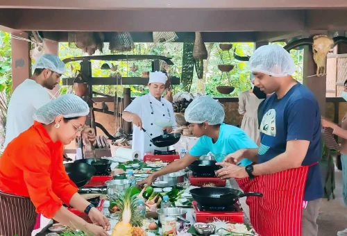Visitors exploring Old Phuket Farm with traditional wooden houses, lush gardens, and authentic Thai rural scenery