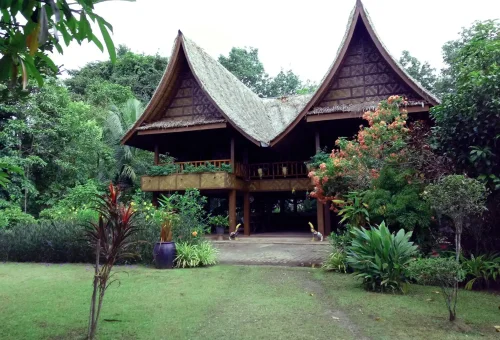 Traditional Thai farmhouse surrounded by greenery at Old Phuket Farm, showcasing rural life and cultural heritage