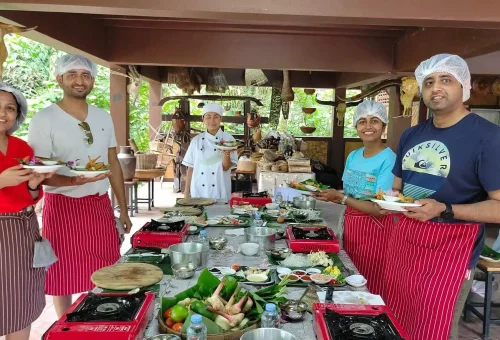 Thai cooking instructor demonstrating traditional techniques at Old Phuket Farm with students watching attentively