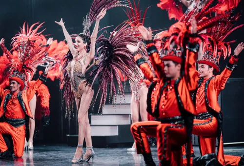 Simon Cabaret Phuket cast performing a high-energy dance routine in elaborate costumes on a vibrant stage.