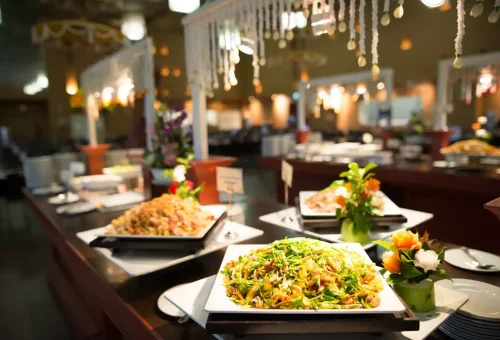 Final curtain call at Siam Niramit Phuket with the full cast in traditional Thai costumes, illuminated by dramatic stage lighting.