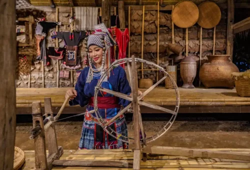 Siam Niramit Phuket performers presenting a graceful Thai dance in traditional silk costumes under soft stage lighting.