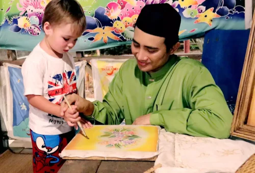 Majestic stage scene at Siam Niramit Phuket with performers reenacting a royal procession in elaborate traditional attire.