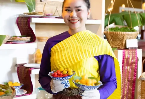 Scene from Siam Niramit Phuket showcasing performers in vibrant traditional costumes during a festive Thai celebration.