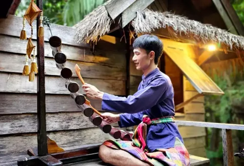 Colorful stage performance at Siam Niramit Phuket depicting a festive Thai celebration with traditional dance and costumes.