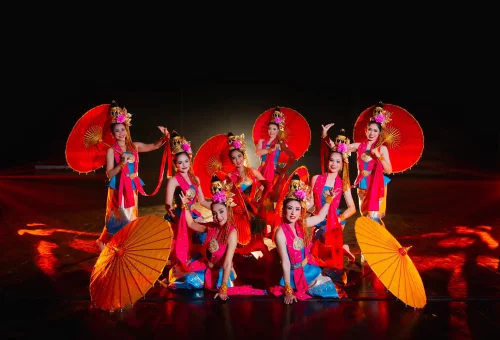 Colorful Thai-style building illuminated at night with visitors exploring Phuket FantaSea