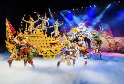 Visitors walking under glowing lanterns and colorful lights at night in Phuket FantaSea