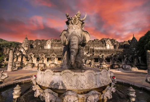 Guests enjoying vibrant light displays and festive decor in the Phuket FantaSea theme park at night