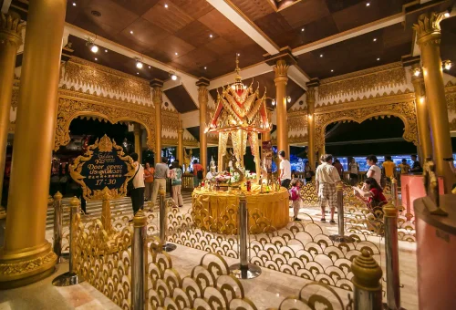Visitors posing in front of the illuminated golden elephant statues at Phuket FantaSea