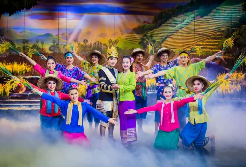 Dancers in traditional Thai costumes performing under vibrant stage lights at Phuket FantaSea Show