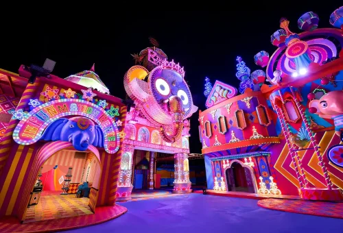 Visitors walking beneath glowing floral light arches at Carnival Magic Phuket at night