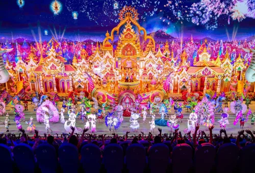 Performer in an elaborate illuminated costume on stage at Carnival Magic Phuket night show