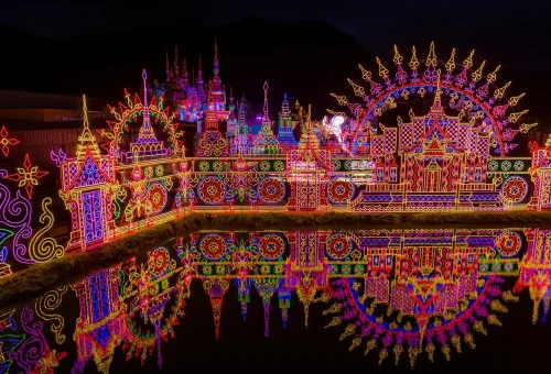 Spectators watching a lively stage performance with colorful costumes and lighting effects at Carnival Magic Phuket
