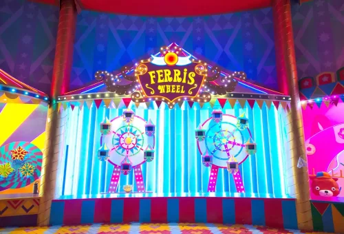 Carnival performers in colorful, glittering costumes on stage at Carnival Magic Phuket