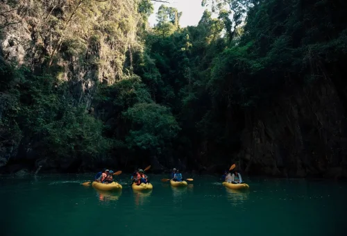 Hong Island in Phang Nga Bay with clear water, limestone cliffs, and a canoe in a peaceful lagoon.