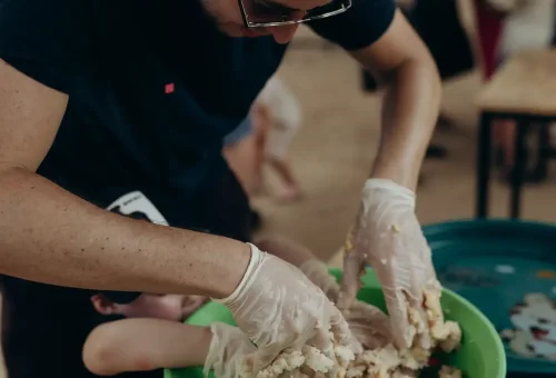 Close-up of visitors shaping rice balls for elephants at Bukit Elephant Park Phuket, part of a feeding activity led by staff
