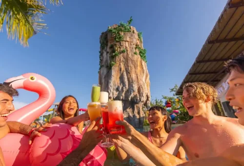Guests lounging by the pool at Andamanda Phuket Waterpark, sipping vibrant, tropical cocktails under the sun.