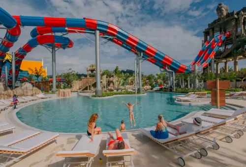 Families and friends enjoying a lively pool scene at Andamanda Phuket Waterpark, with floaties, splashes, and sunshine all around.