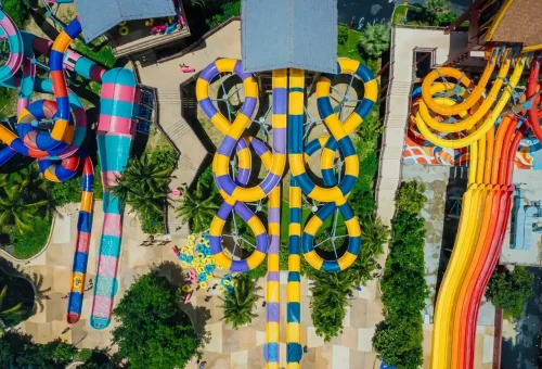 Guests enjoying a variety of dynamic water sliders at Andamanda Phuket Waterpark, with vibrant colors and joyful splashes all around.
