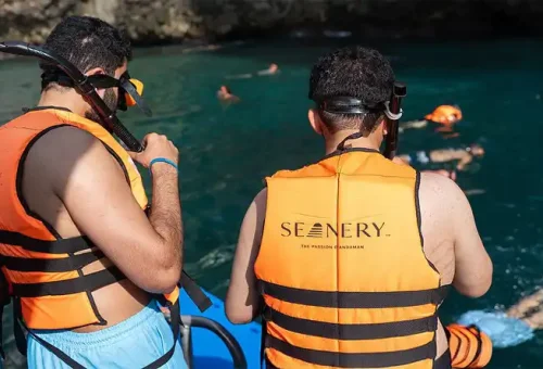 Guests preparing to snorkel off the back of a speed catamaran at Phi Phi Islands, wearing life vests and surrounded by clear turquoise water.