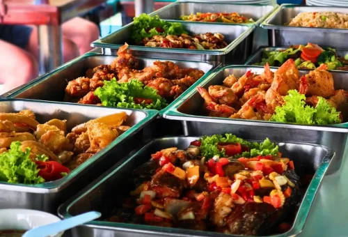A vibrant Thai lunch buffet served on board during the Andaman Sea Kayak tour, featuring curries, rice, vegetables, and tropical fruits with ocean views.