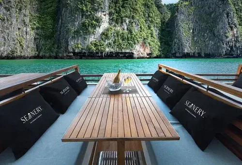 Elegant deck setting on a luxury catamaran near James Bond Island, featuring cozy seating, decorative cushions, and panoramic sea views.